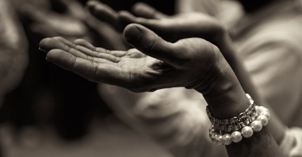 Close-up of expressive hands in prayer wearing a bracelet, conveying faith and devotion.