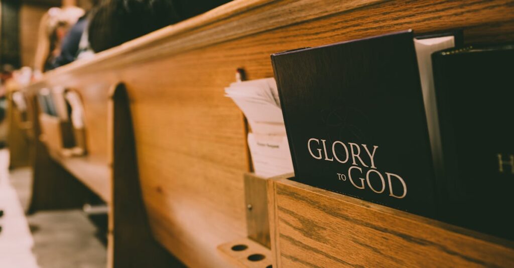 A close-up of a wooden church pew holding hymnals and a Bible, symbolizing worship.