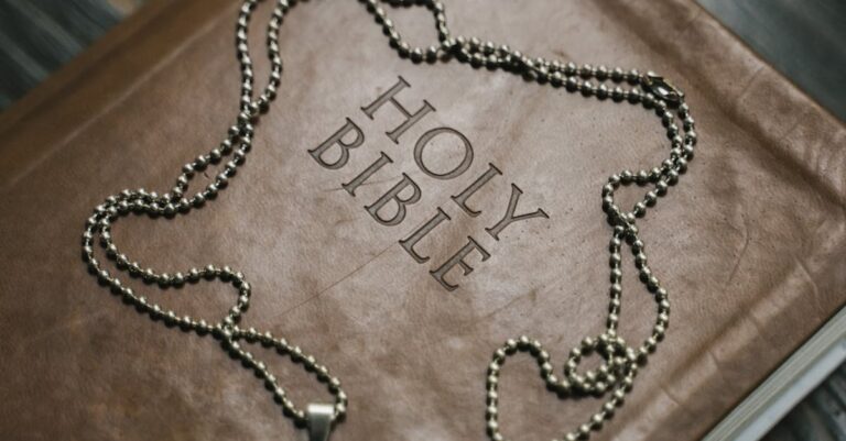 Close-up image of a Holy Bible with a cross necklace, emphasizing Christian faith.